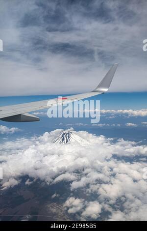 Un'ala di aeroplano sopra il Monte Fuji in Giappone. Vista aerea dal finestrino passeggero. Foto Stock