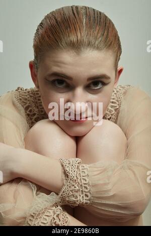 giovane transgender con la cosmesi femminile sorride, guarda la macchina fotografica, immagine closeup Foto Stock