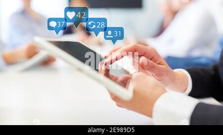 La donna d'affari usa i social media sul tablet pc in ufficio durante la riunione Foto Stock