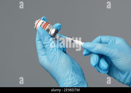 Vaccinazione e immunizzazione. Mani in guanti blu siringa di riempimento con vaccino Coronavirus Foto Stock