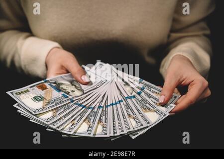 Vista ravvicinata dei dollari. Conti donna, bilancio casa di pianificazione, contabile che lavora in ufficio. Concetto di finanze, investimenti, risparmio di denaro. Foto Stock