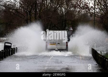 Un pulmino attraversa le acque alluvionali di Laleham-on-Thames, Surrey, dopo lo scoppio delle rive del Tamigi. Data immagine: Mercoledì 3 febbraio 2021. Foto Stock