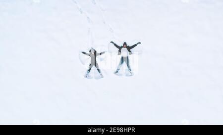 Felice giovane coppia che fa angeli di neve. Angolo alto. Foto di alta qualità Foto Stock