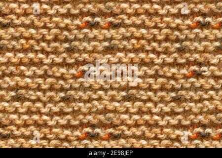 Marrone giallo Beige colore tessuto Knitwear. Istantanea macro trama Unione macchina. Beige lavorato a maglia sfondo. Foto Stock