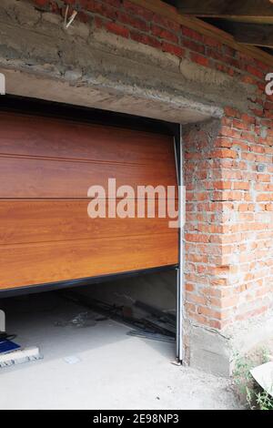 Primo piano di installazione di pannelli porta garage in muratura costruzione casa. Foto Stock