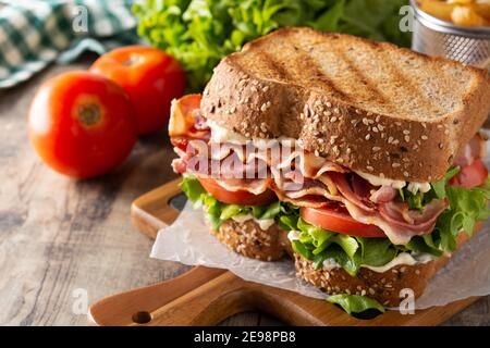 BLT sandwich e patatine fritte su tavolo di legno Foto Stock