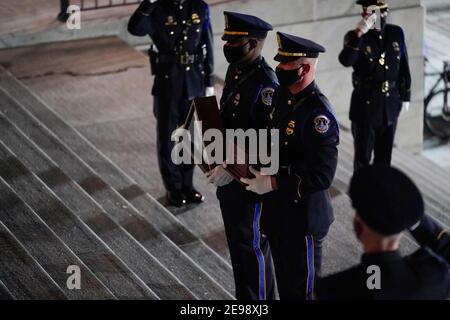 Una guardia d'onore porta un'urna con i resti cremati dell'ufficiale della polizia del Campidoglio degli Stati Uniti Brian Sicknick e ha ripiegato la bandiera sui gradini del Campidoglio degli Stati Uniti per giacere in onore nella Rotunda, martedì 2 febbraio 2021, a Washington. (Foto di Alex Brandon/Pool/Sipa USA) Foto Stock