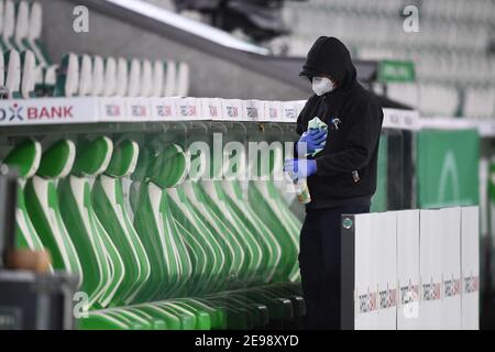 03 febbraio 2021, bassa Sassonia, Wolfsburg: Calcio: Coppa DFB, VfL Wolfsburg - FC Schalke 04, round del 16 alla Volkswagen Arena. Un assistente disinfetta il banco prima della partita. NOTA IMPORTANTE: In conformità con le normative della DFL Deutsche Fußball Liga e della DFB Deutscher Fußball-Bund (Associazione tedesca del calcio), è vietato utilizzare o utilizzare fotografie scattate nello stadio e/o della partita sotto forma di sequenze di immagini e/o serie di foto di tipo video. Foto: Swen Pförtner/dpa Foto Stock