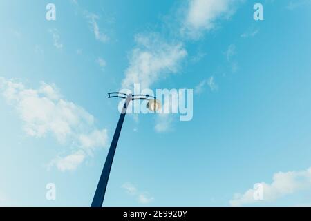 Un'ampia gamma di angoli minimalistici scattata da una streetlight con un cielo blu come sfondo con spazio di copia Foto Stock