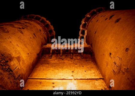 Fortificazione medievale torri 'Torres de Quart' con visable canon colpi in arancione illuminata notte a Valencia, Spagna Foto Stock