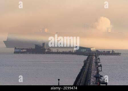 Southend on Sea, Essex, Regno Unito. 3 Feb 2021. L'HMM le Havre è visto passare Southend sul molo del mare sull'estuario del Tamigi nel tardo pomeriggio e scomparire in nebbia dopo aver lasciato il DP World London Gateway Port. La nave container di classe Algeciras è una delle più grandi mai costruite, entrata in servizio nell'agosto 2020, in grado di trasportare quasi 24000 container, e serve la rotta ad anello dell'Europa dell'Estremo Oriente 3. Il Regno Unito sta facendo domanda di adesione all’accordo globale e progressista per la Trans-Pacific Partnership - o CPTPP - che include i paesi dell’Estremo Oriente serviti da navi giganti come questa Foto Stock
