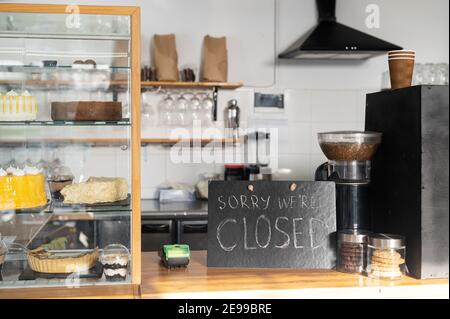 Cartello chiuso al banco bar in una caffetteria vuota. Caffetteria, bar chiuso a causa della chiusura dell'epidemia. Concetto di crisi delle piccole imprese Foto Stock
