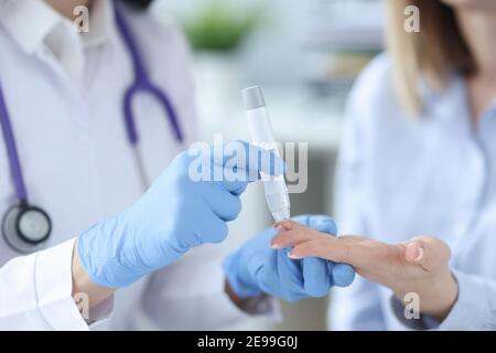 Infermiere che preleva il sangue dal paziente con closeup di lancette Foto Stock