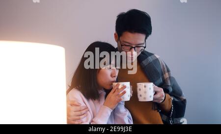 Giovane coppia asiatica bevendo tè caldo e guardando un film. Concetto di amore e affetto . Foto di alta qualità Foto Stock