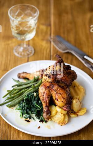 poussin arrosto con patate, purè di sudore, fagioli verdi e spinaci cremosi Foto Stock