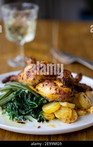 poussin arrosto con patate, purè di sudore, fagioli verdi e spinaci cremosi Foto Stock