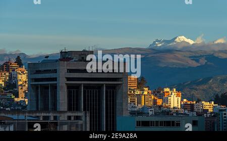 Panorama urbano di Quito al tramonto con il vulcano Antisana innevato, Ecuador. Foto Stock