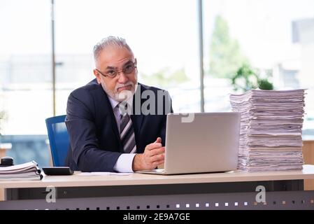 Il vecchio dipendente dell'uomo d'affari non è soddisfatto del lavoro eccessivo Foto Stock