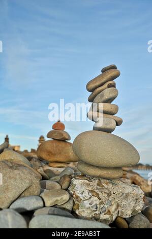 Rocce e pietre lisce e di forma stranamente accatastate alte, equilibrate precariosamente, al tramonto, costa californiana, USA Foto Stock