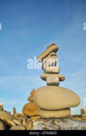 Rocce e pietre lisce e di forma stranamente accatastate alte, equilibrate precariosamente, al tramonto, costa californiana, USA Foto Stock