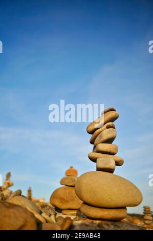 Rocce e pietre lisce e di forma stranamente accatastate alte, equilibrate precariosamente, al tramonto, costa californiana, USA Foto Stock