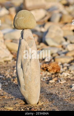 Rocce e pietre lisce e di forma stranamente accatastate alte, equilibrate precariosamente, al tramonto, costa californiana, USA Foto Stock