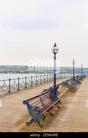 Panchine e lampade sullo storico molo vittoriano a Swanage Bay a Swanage, Isola di Purbeck sulla Jurassic Coast, Dorset, Inghilterra sud-occidentale Foto Stock