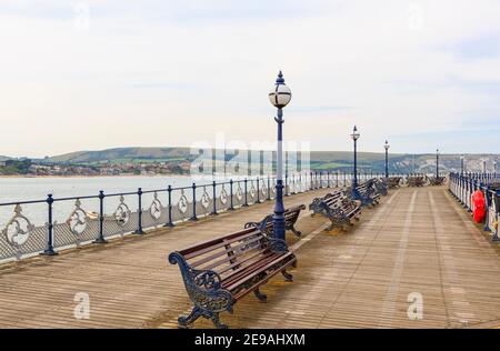 Panchine e lampade sullo storico molo vittoriano a Swanage Bay a Swanage, Isola di Purbeck sulla Jurassic Coast, Dorset, Inghilterra sud-occidentale Foto Stock