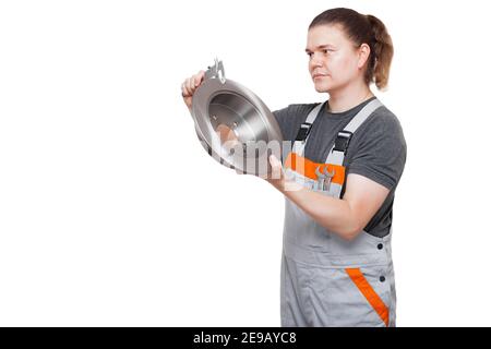 lavoratore maschile in uniforme di macchina meccanica di lavoro con chiave la chiave nella tasca tiene il disco del freno a mano misura la dimensione di pezzi di ricambio per auto con pinza t Foto Stock