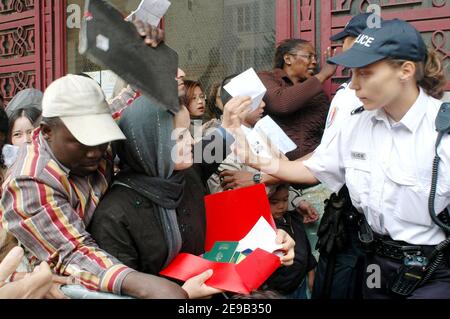 Centinaia di residenti illegali in Francia (soprattutto asiatici e africani) si sono accodati presso il centro di polizia degli stranieri, Rue Truffaut, a Parigi, Francia, il 28 giugno 2006, per chiedere la regolarizzazione dopo il ministro degli interni francese Nicolas Sarkozy, Ha annunciato che la Francia concederà permessi di soggiorno ad alcuni migranti illegali i cui figli frequentano la scuola. Foto di Alain Apaydin/ABACAPRESS.COM Foto Stock