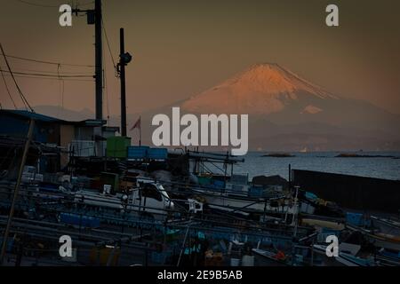 Un'alba di gennaio del Monte Fuji visto da un porticciolo sulla Baia di Sagami in Giappone. Foto Stock