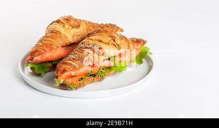 Panino di croissant con salmone e foglie di insalata Foto Stock