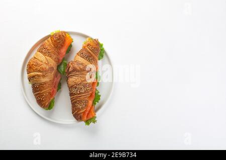 Panino croissant con salmone e foglie di insalata, vista dall'alto Foto Stock