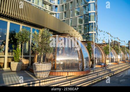 Londra, UK- 15 Dic 2020: Igloos ristorante all'aperto, molte sale di servizio separate in una fila. Gli igloos sul lungofiume del Coppa Club, che si affacciano sul Tower Bridge Foto Stock