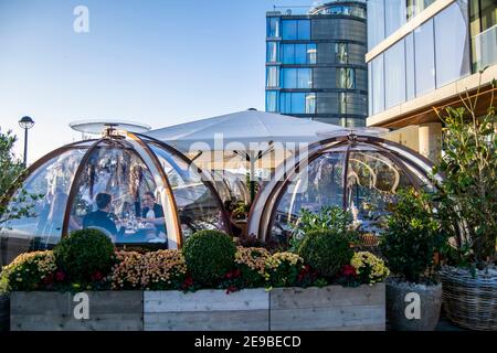 Londra, UK- 15 Dic 2020: Ristorante all'aperto igloo separato sala di servizio in cui è un gruppo di persone caucasiche mangiare e parlare insieme. Coppa Club Foto Stock