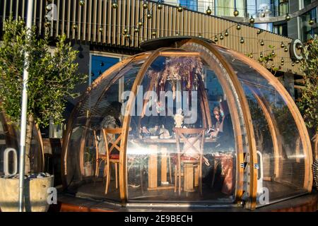 Londra, UK- 15 Dic 2020: Ristorante all'aperto igloo separato sala di servizio in cui cameriera che serve donne musulmane che indossano burkas. Coppa Club's Riverside Foto Stock