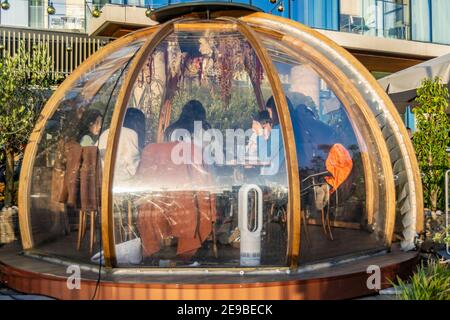 Londra, UK- 15 Dic 2020: Ristorante all'aperto igloo separato sala di servizio in cui è un gruppo di persone asiatiche mangiare e parlare insieme. Coppa Club's. Foto Stock