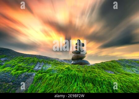 Ciottoli accatastati arte sulle rocce di muschio accoglie favorevolmente Bella nuovo giorno Foto Stock