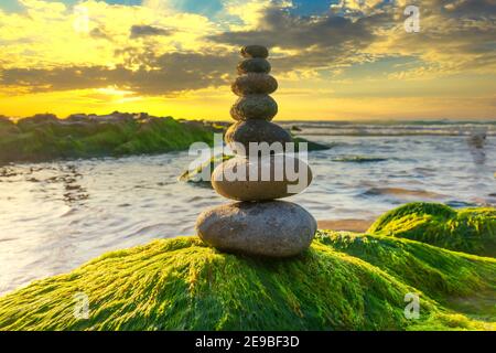 Ciottoli accatastati arte sulle rocce di muschio accoglie favorevolmente Bella nuovo giorno Foto Stock