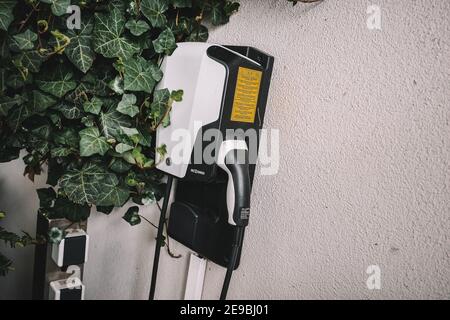 Cavo di carica nel pannello di carica di un veicolo elettrico. Il punto di ricarica alimentato dal sistema di stoccaggio della batteria. Foto Stock