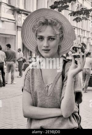 Ritratto di una ragazza in un cappello di paglia che vende bambole piccole. Arbat Street, 80s-90s, Mosca, capitale; Russia, Foto Stock