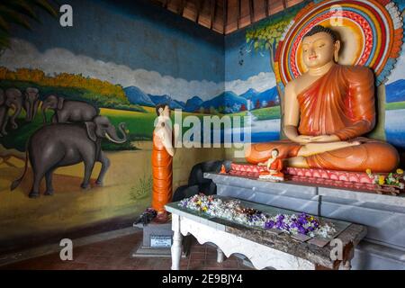 L'interno colorato della casa immagine al tempio buddista Sigiriya a Sigiriya, nel centro dello Sri Lanka. L'interno è dominato da un Budd seduto Foto Stock