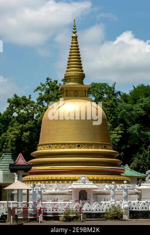 Lo splendido stupa dorato adiacente al Tempio d'Oro di Dambulla nel centro dello Sri Lanka. Il Tempio d'Oro fu costruito nel 2000. Foto Stock