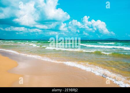 Bella stagione. Splendida spiaggia di sabbia gialla, mare azzurro e cielo blu con belle nuvole. Mare della Cina del Sud. Isola paradisiaca di Hainan, Sanya. Foto Stock