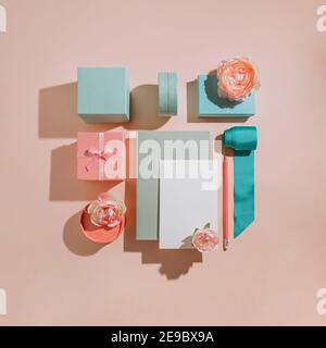 Composizione geometrica di scatole regalo con fiori, mockup per carte, inviti in colori pastello muti. Layout romantico per un invito al matrimonio Foto Stock