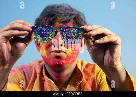UN GIOVANE CHE TIENE GLI OCCHIALI DI PROTEZIONE RIEMPITI DI GULAL Foto Stock