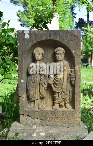 Scultura di due uomini romani su una pietra nella città di Djemila, Setif, Algeria Foto Stock