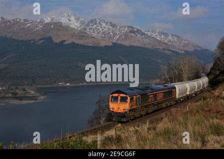 Un GBRf Classe 66 in direzione sud che trasporta carri di allumina vuoti da Fort William a Lynemouth tra Arrochar e Glen Douglas. Foto Stock