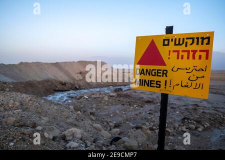 Un cartello di avvertimento posto sul sito della barriera di sale lungo il confine con la Giordania il 13 settembre 2022, nel Mar Morto, Israele. L'esercito israeliano sta costruendo un progetto unico di una barriera di sale naturale a sud dell'insediamento israeliano di Neot HaKikar nella zona meridionale del Mar Morto, la parete di sale estratta dal Mar Morto raggiungerà un'altezza massima di 13 metri (42 piedi) per 40 km (24 miglia) E renderà difficile per gli infiltrati attraversare il confine dalla Giordania. Foto Stock