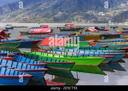 Barche colorate in legno presso il lago Phewa di Pokhara, Nepal Foto Stock